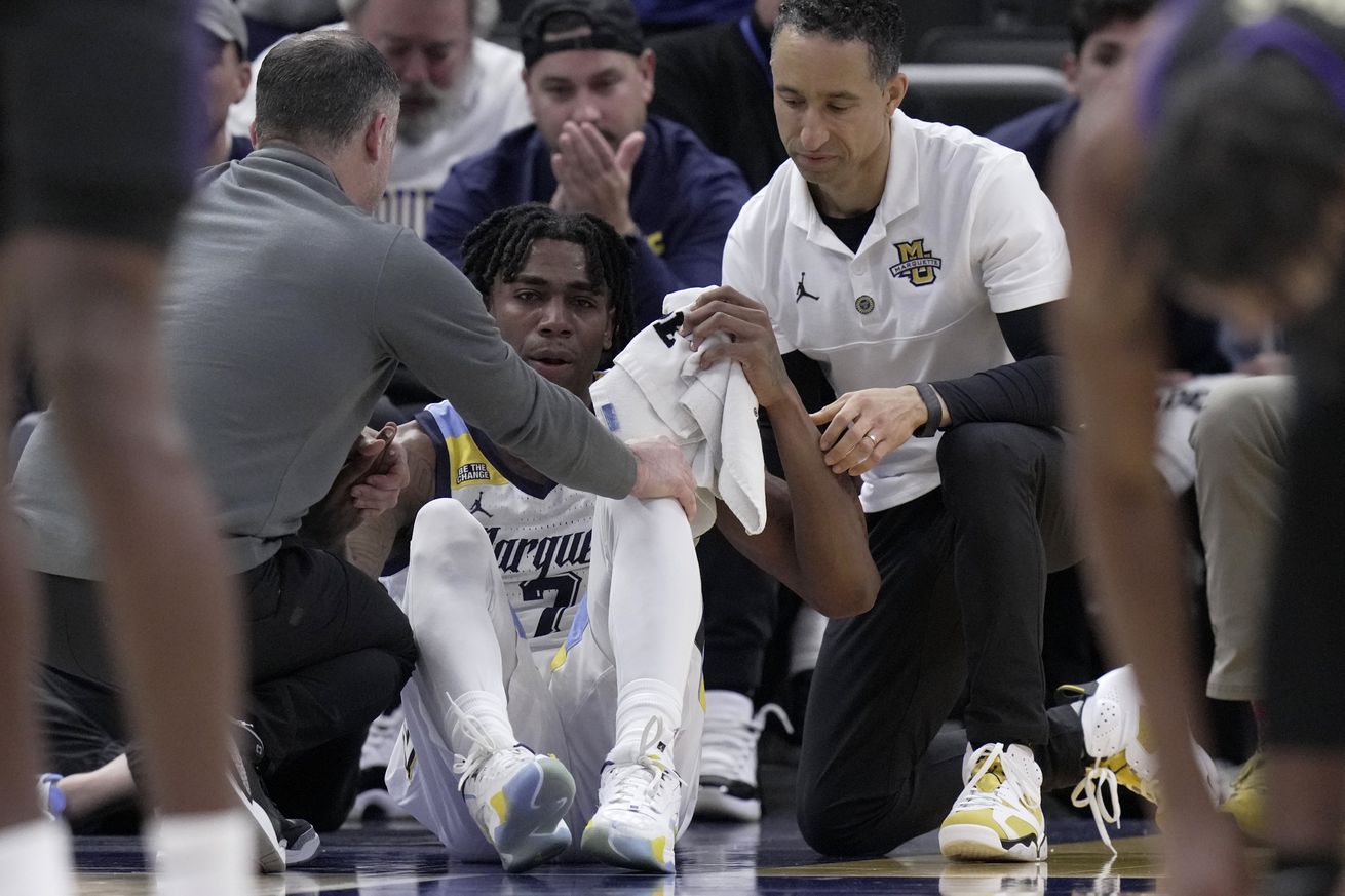 Marquette Golden Eagles guard Zaide Lowery is assisted by head coach Shaka Smart (right) and a trainer after suffering an apparent injury during the second half against the Western Carolina Catamounts at Fiserv Forum. Marquette won 94-62.