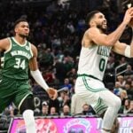 Nov 10, 2024; Milwaukee, Wisconsin, USA; Boston Celtics forward Jayson Tatum (0) takes a shot against Milwaukee Bucks forward Giannis Antetokounmpo (34) in the third quarter at Fiserv Forum. Mandatory Credit: Benny Sieu-Imagn Images