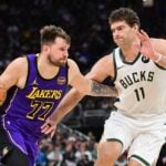 Mar 13, 2025; Milwaukee, Wisconsin, USA; Los Angeles Lakers guard Luka Doncic (77) drives to the basket against Milwaukee Bucks center Brook Lopez (11) in the fourth quarter at Fiserv Forum. Mandatory Credit: Benny Sieu-Imagn Images