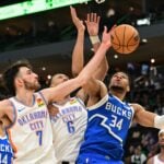 Mar 16, 2025; Milwaukee, Wisconsin, USA; Milwaukee Bucks forward Giannis Antetokounmpo (34) reaches for the ball against Oklahoma City Thunder center Chet Holmgren (7) and forward Jaylin Williams (6) in the fourth quarter at Fiserv Forum. Mandatory Credit: Benny Sieu-Imagn Images