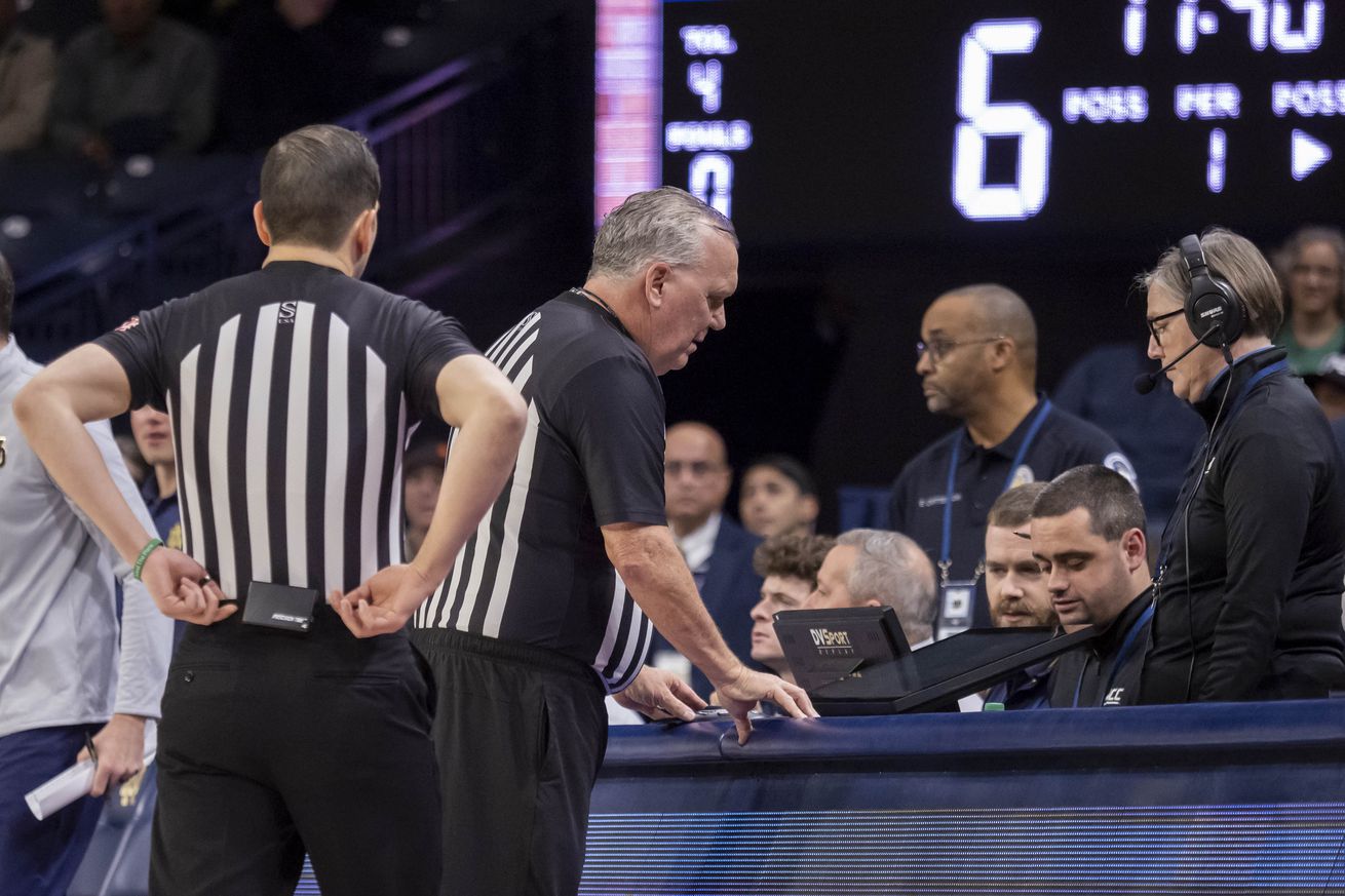 ACC conference official review a play on the DVSPORT replay monitor during a college basketball game between the Virginia Cavaliers and the Notre Dame Fighting Irish on December 30, 2023 at Purcell Pavilion in South Bend, Indiana.