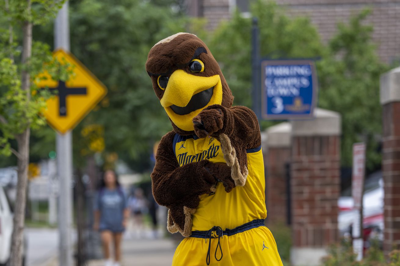 Iggy, the Marquette Mascot, standing in the 800 block of North 16th Street outside of Sendik’s, facing south, pointing at the camera.